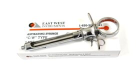 A syringe is sitting on the card of an east west instrument.